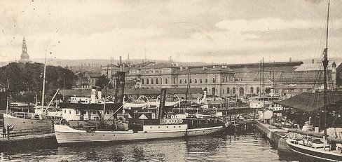 Gammelt bilde av kristiania havn med jernbanestasjonen i bakgrunnen.